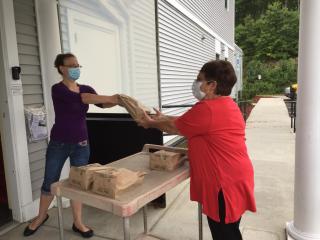 Masked Women Exchanging a Package